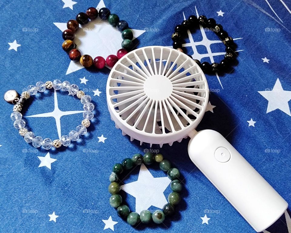 Hand jewelry and chargeable fan in a closed shape photo.