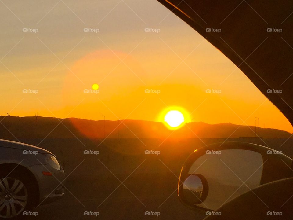 Enjoying the moon and sunset from moving car on highway 