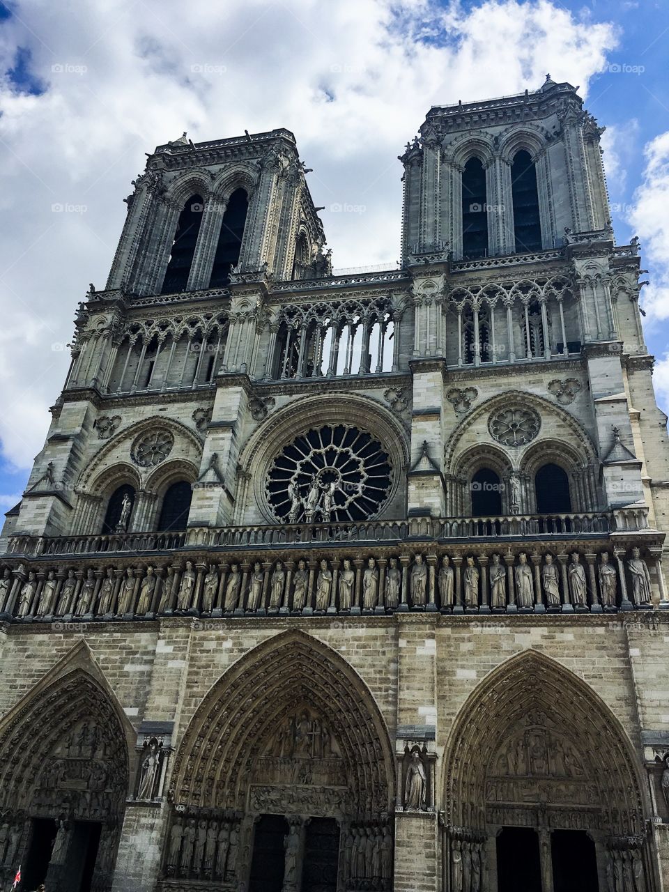 The Notre Dame cathedral from the outside. The sky is mostly cloudy, but the cathedral takes up most of the shot.