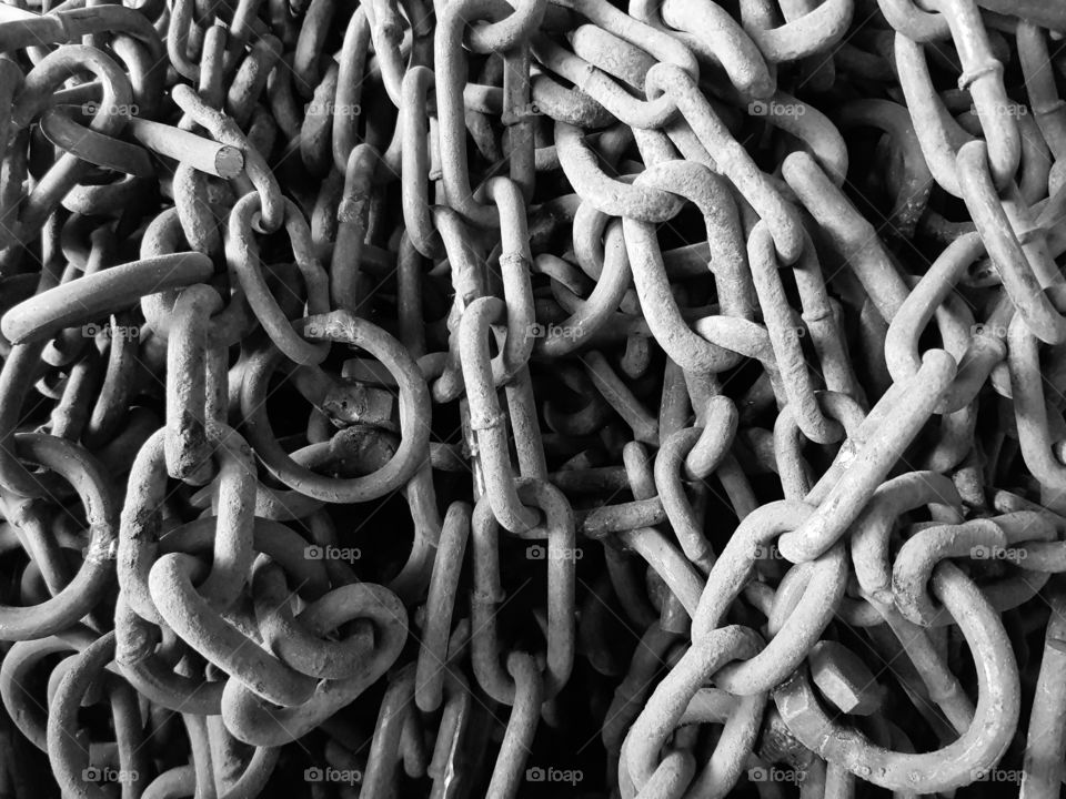 black and white photo of hard rusty chain . ellipse shapes of metal