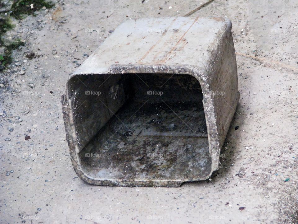 Close-up view of a small plastic trash can that has fallen in a dirty and unkempt condition in high angle view