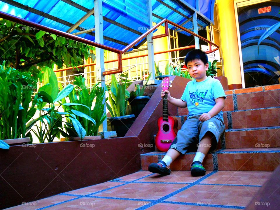 asian child with a yukelele or small guitar