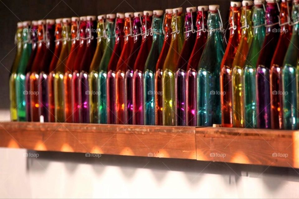 Many colorful glass bottles with swing tops stand in a row