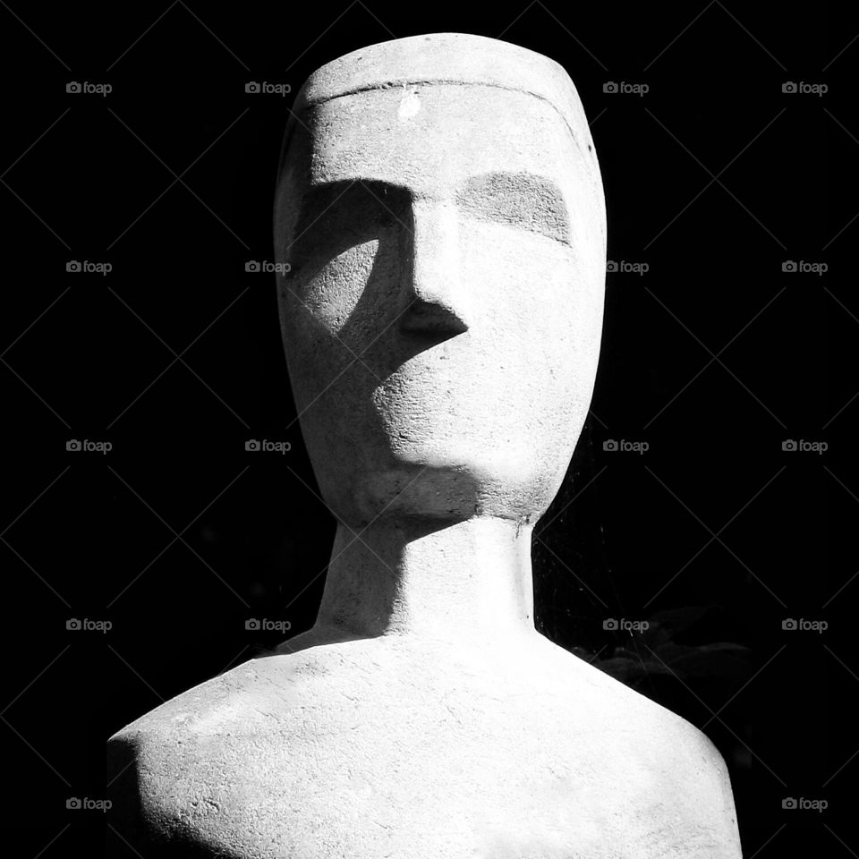 Stone man. A black and white head shot of a stone statue.