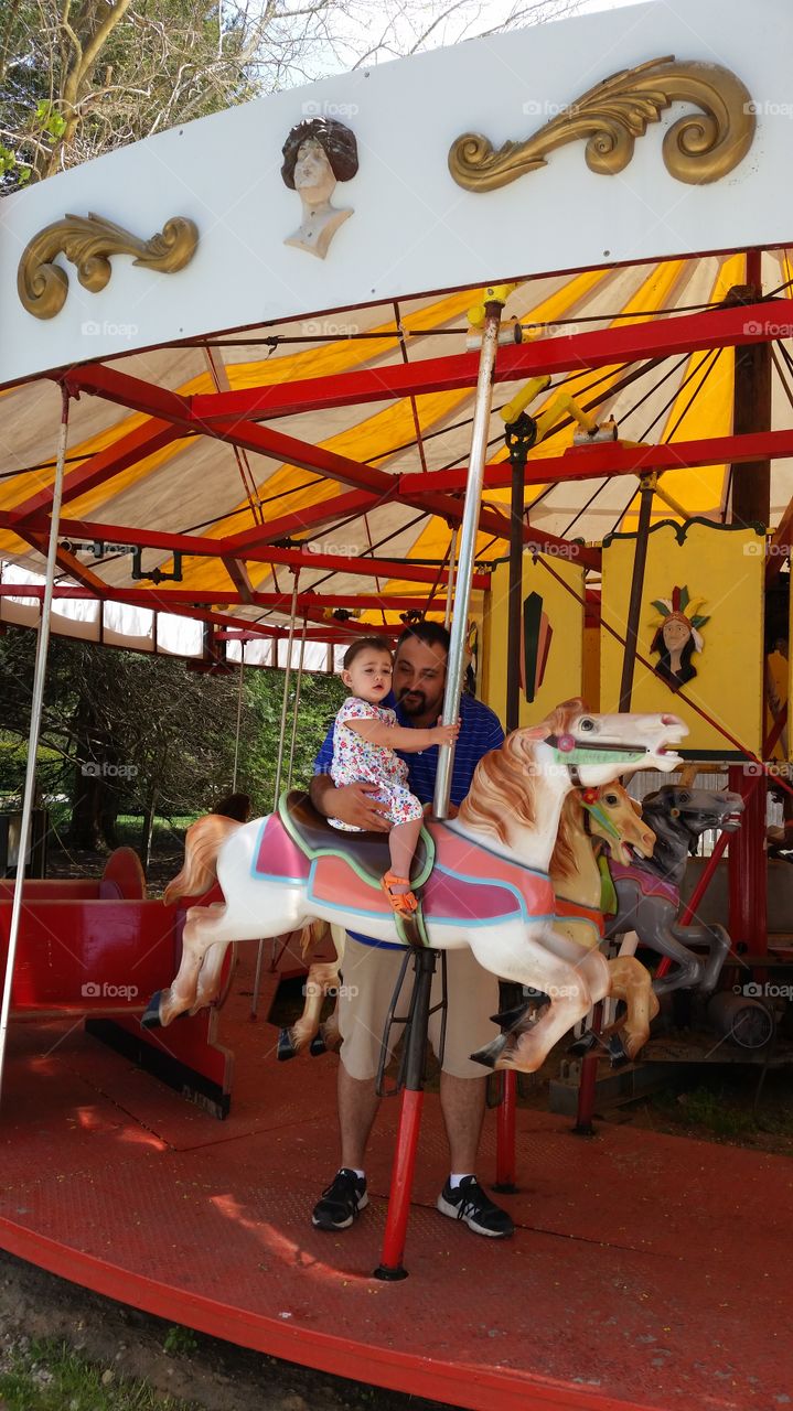 daddy and daughter on a merry go round