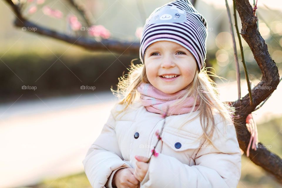 Candid lifestyle portrait of happy little Caucasian girl outdoor