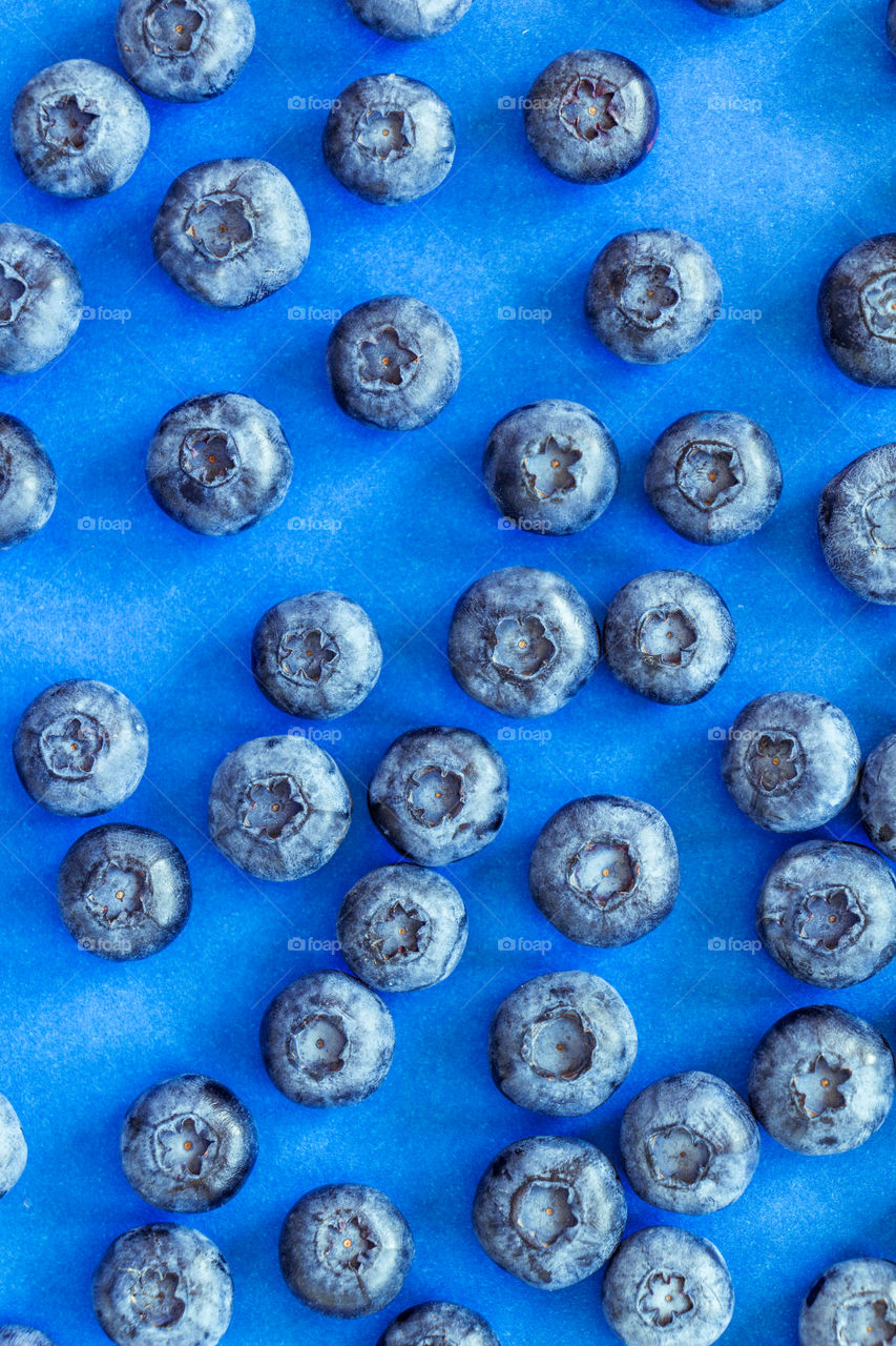 A lot of fresh blueberries on blue background. Can be used for summer, food, nutrition, healthy, lifestyle, fresh, organic themes
