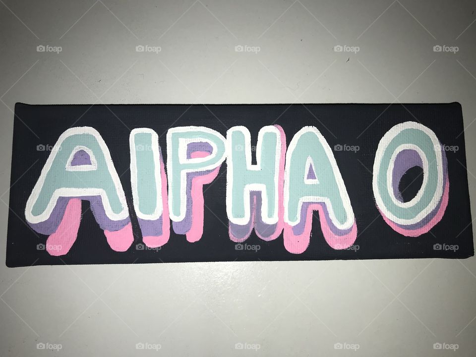 Alpha omicron pi painted canvas sign with purple blue and pink letters outlined in white on a black background 