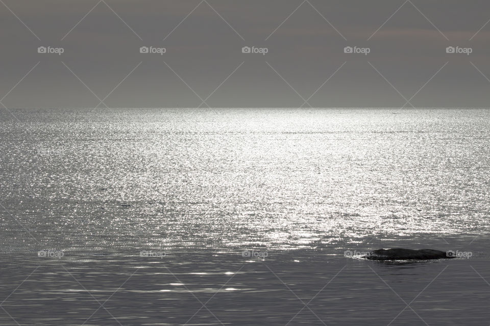 Rock in glittering sea 