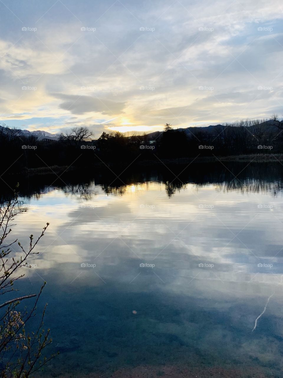 Mixture of clouds and sun reflecting off of quail pond in Southern Colorado Springs