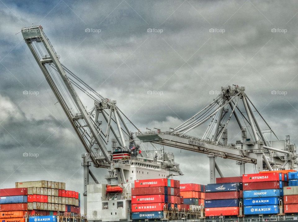 Cargo Containers Loading At A Seaport. Giant Cranes Loading Cargo On A Merchant Ship
