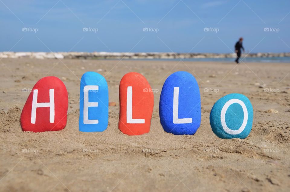 Hello on colourful stones with beach