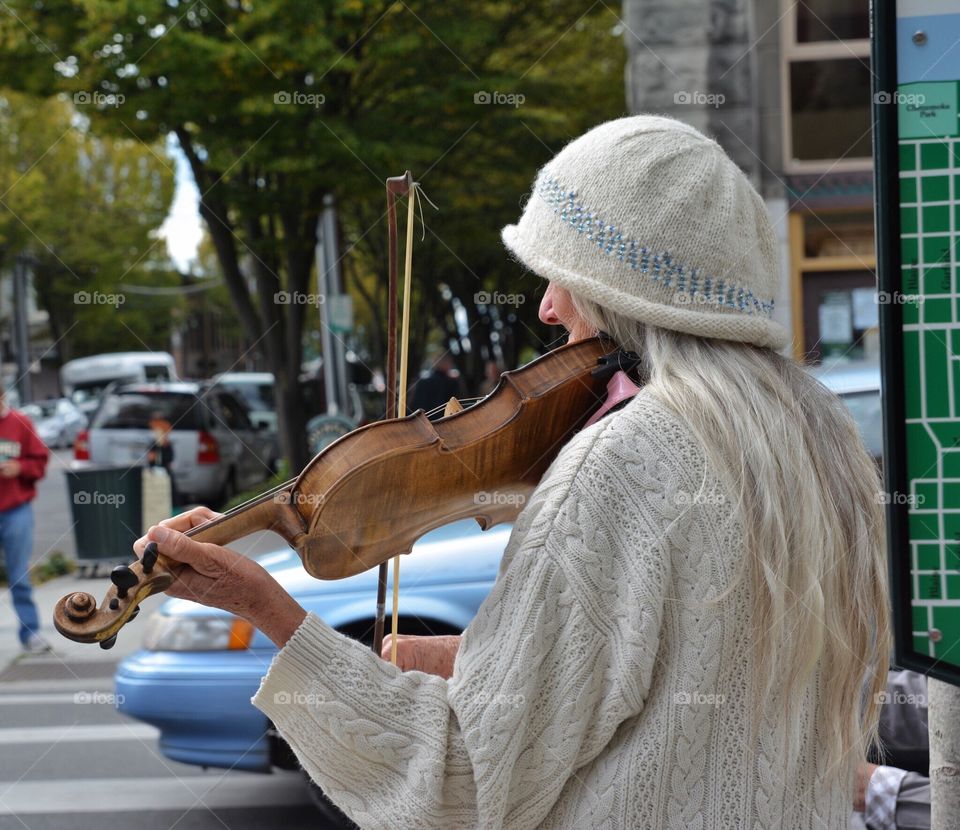 Elderly Woman playing violin on street corner
