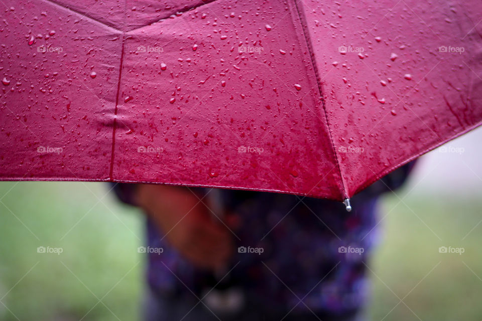 Child with wet red umbrella