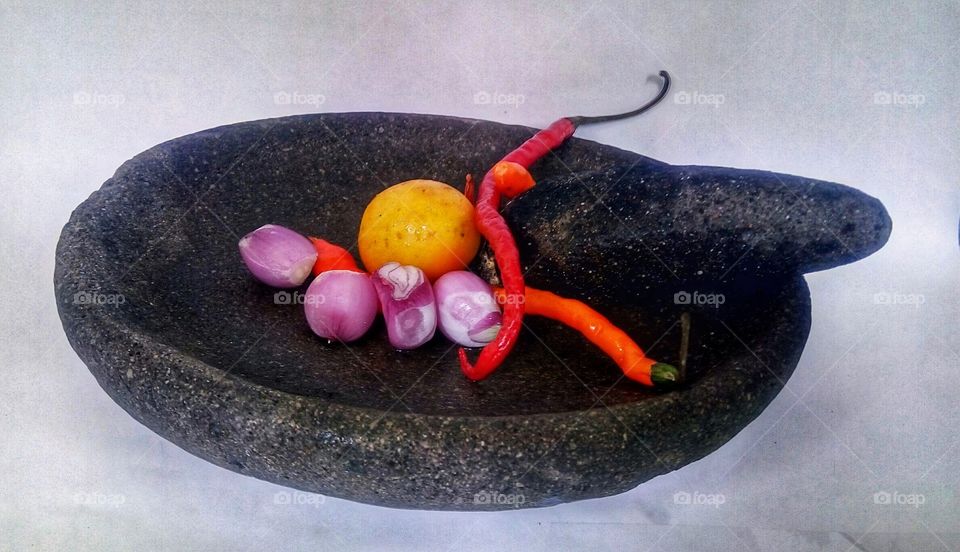 chili onion is a traditional Indonesian food that is grinded with a stone which is called chili sauce
