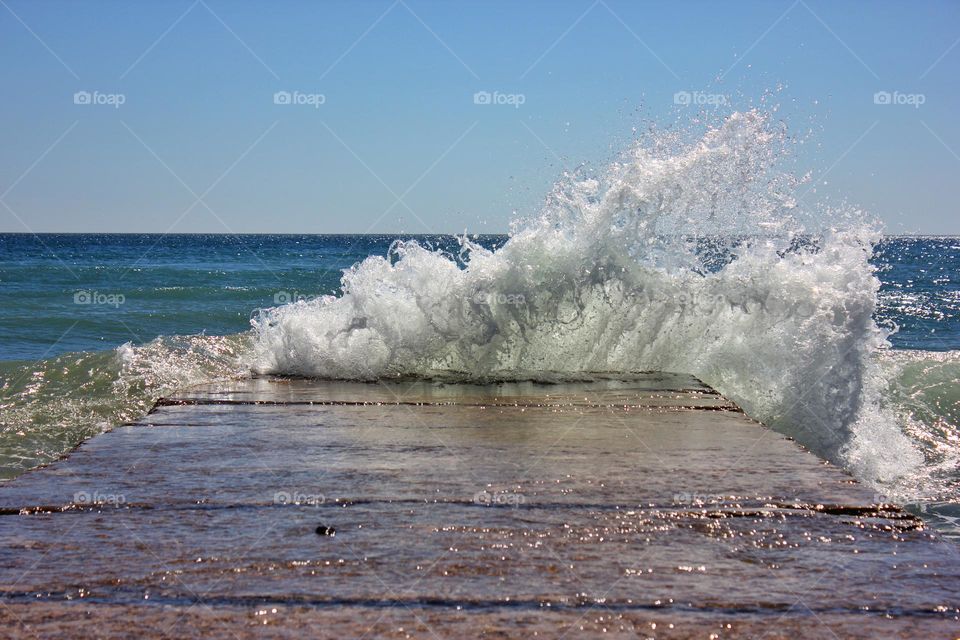 a wave hits the shore