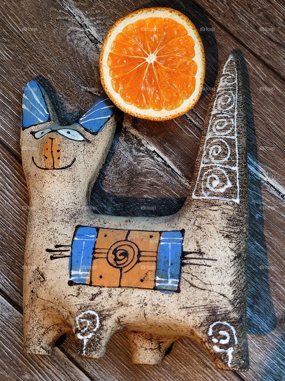 Clay figurine of a cat and an orange slice