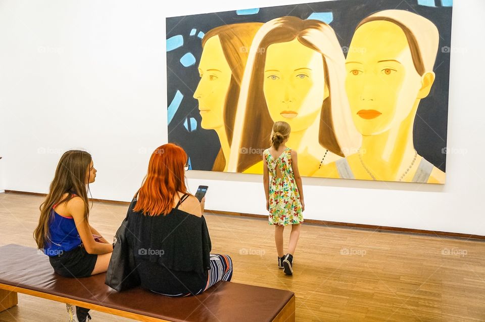 Women sitting in front of picture frame