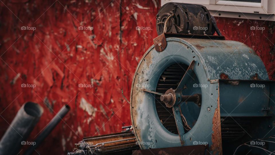 Old turbine next to old barn.