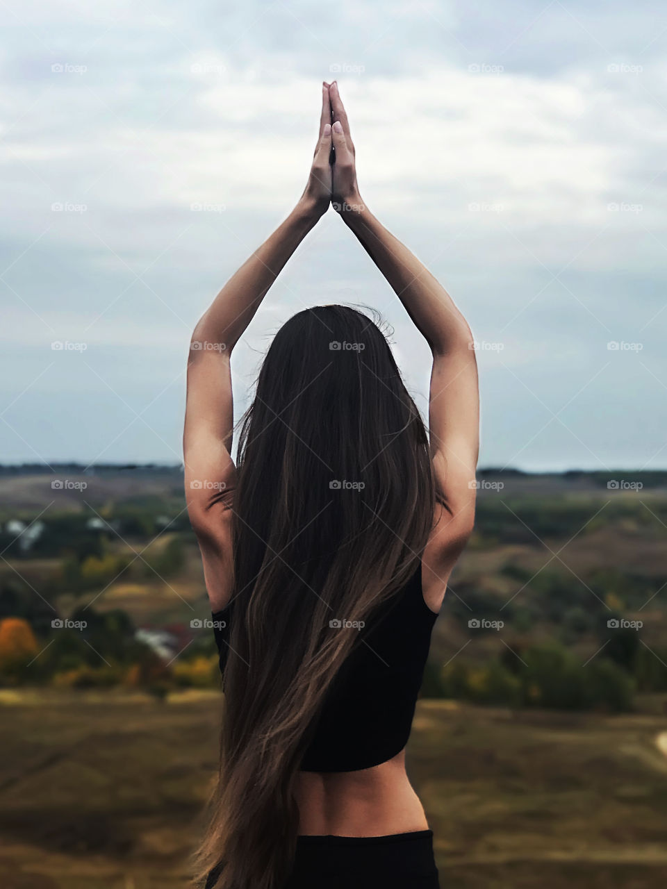 Young woman with long hair doing yoga outdoor 