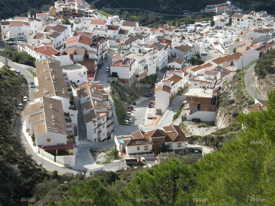 View of a traditional Andalusian white village from the surrounding mountains. 