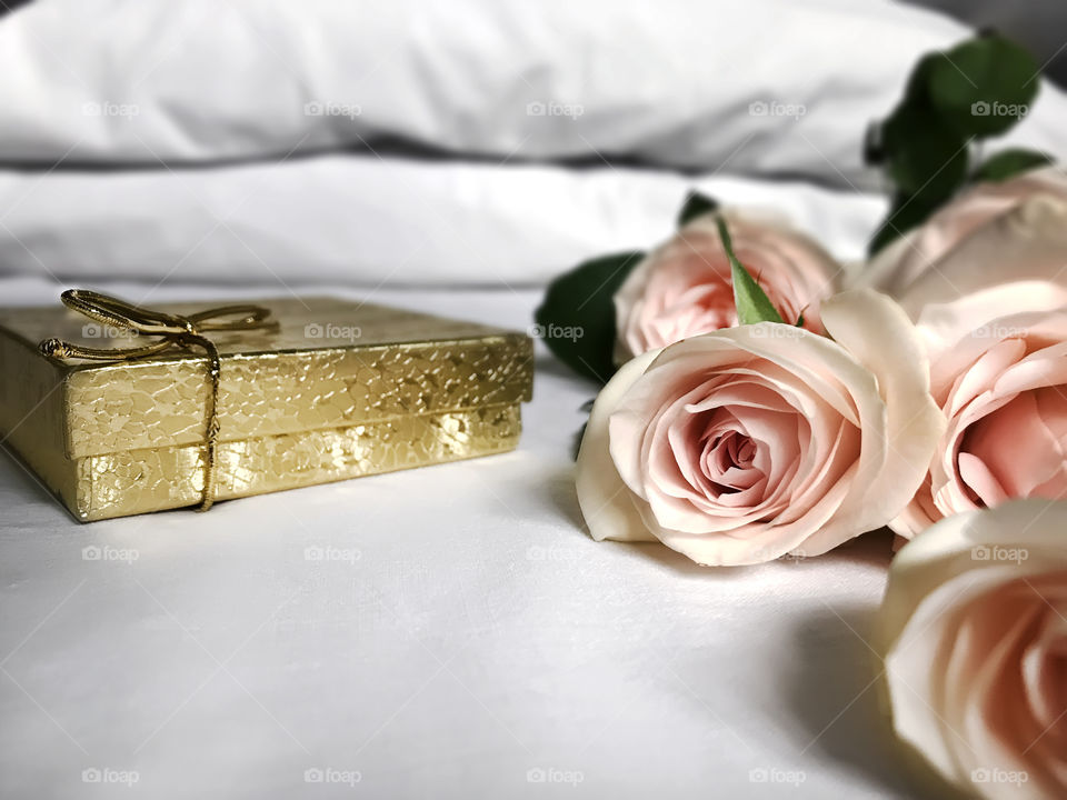 Gift and roses in bed 