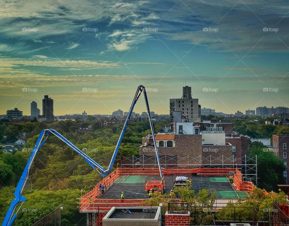 Concrete boom arm pouring a cement floor at a construction site 