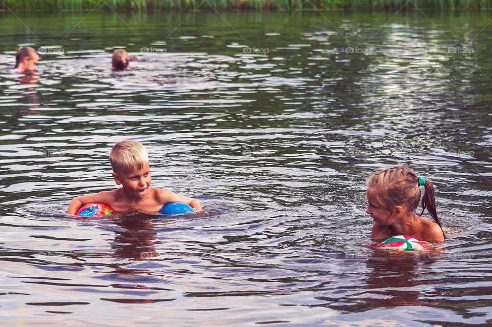 Kids are swimming in the lake