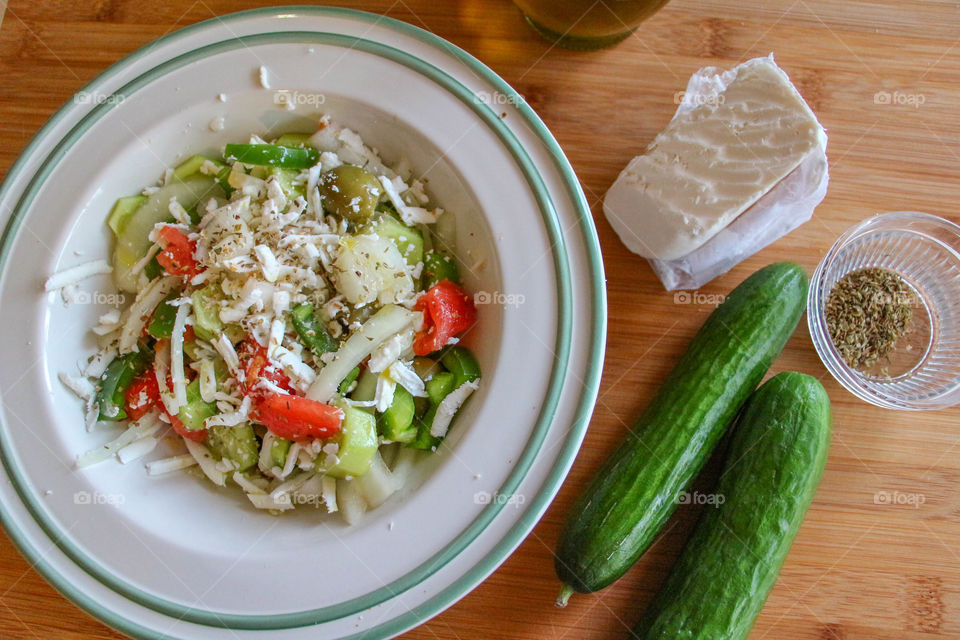 Greek salad and cucumber on table