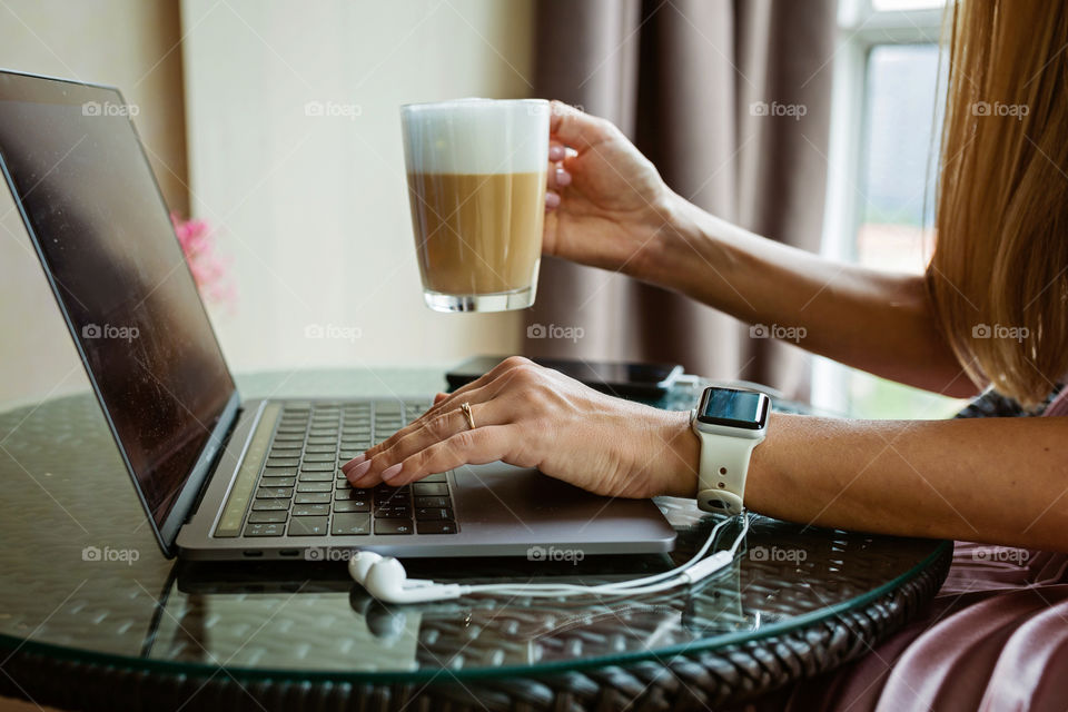 Woman using laptop and drinking coffee 