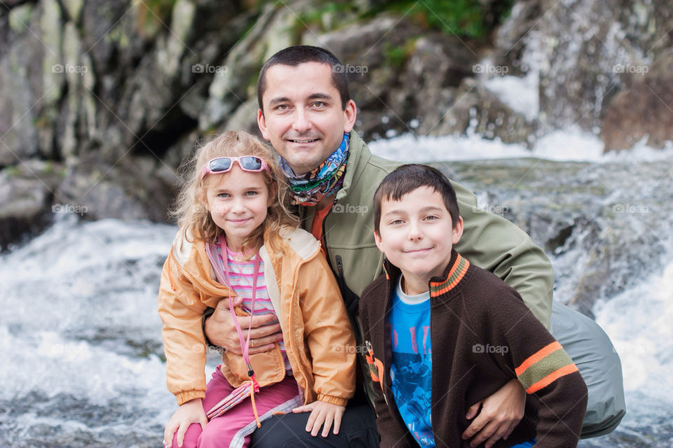 Family sitting close to mountain stream