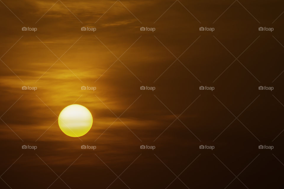 The golden light of the sun and clouds in the sky.