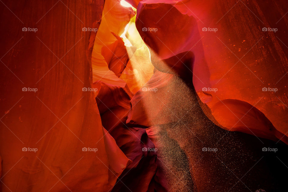 Sand dances in the Light beams that illuminate the beautiful oranges in Antelope Canyon. 