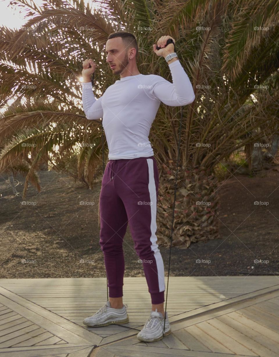 man training in the street with elastic bands doing various exercises