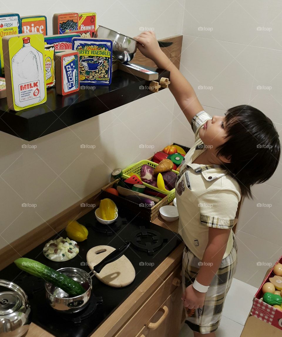 kid in the kitchen. young chef looking for food ingredients