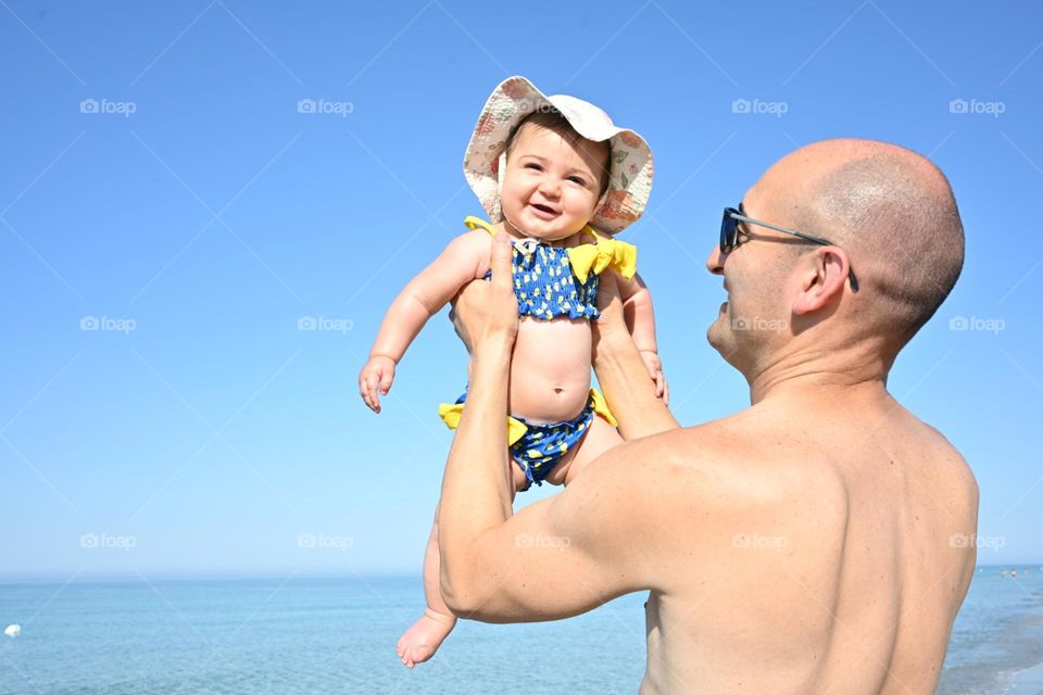 father and daughter playing on the beach
