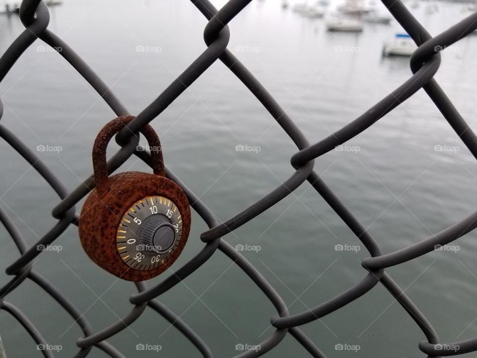 Rusty lock on a fence by the sea