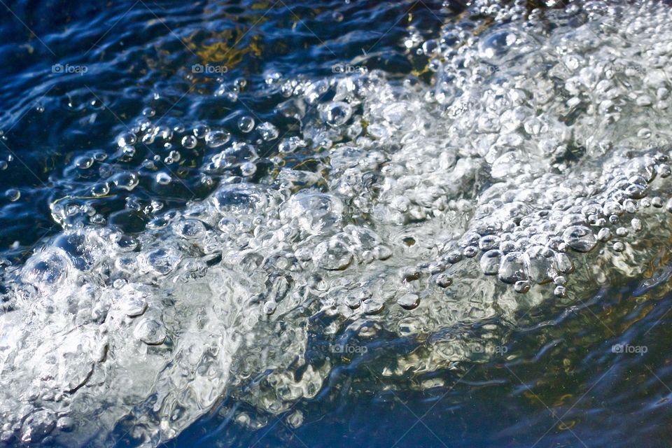 Isolated view of water splashing, reflecting a deep blue sky