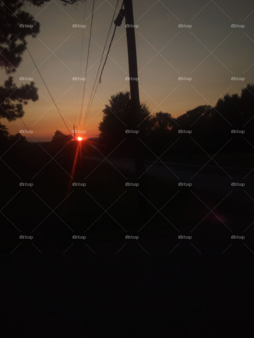 as the sun sets beautiful red ball in the sky. the end of the day preparing for a new.