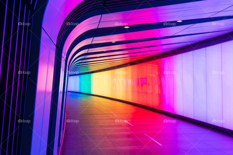 Futuristic rainbow colorful illuminated open road tunnel with no traffic.