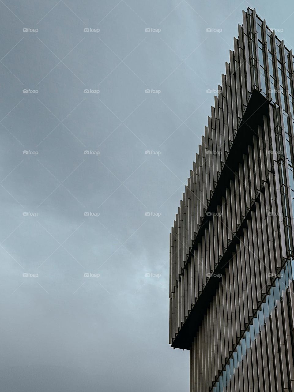 Modern minimalistic office building, dark grey sky in the background, monochrome and minimalistic