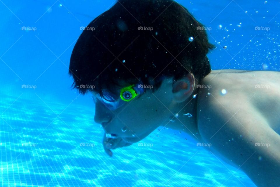 Kid swimming by keeping breath underwater