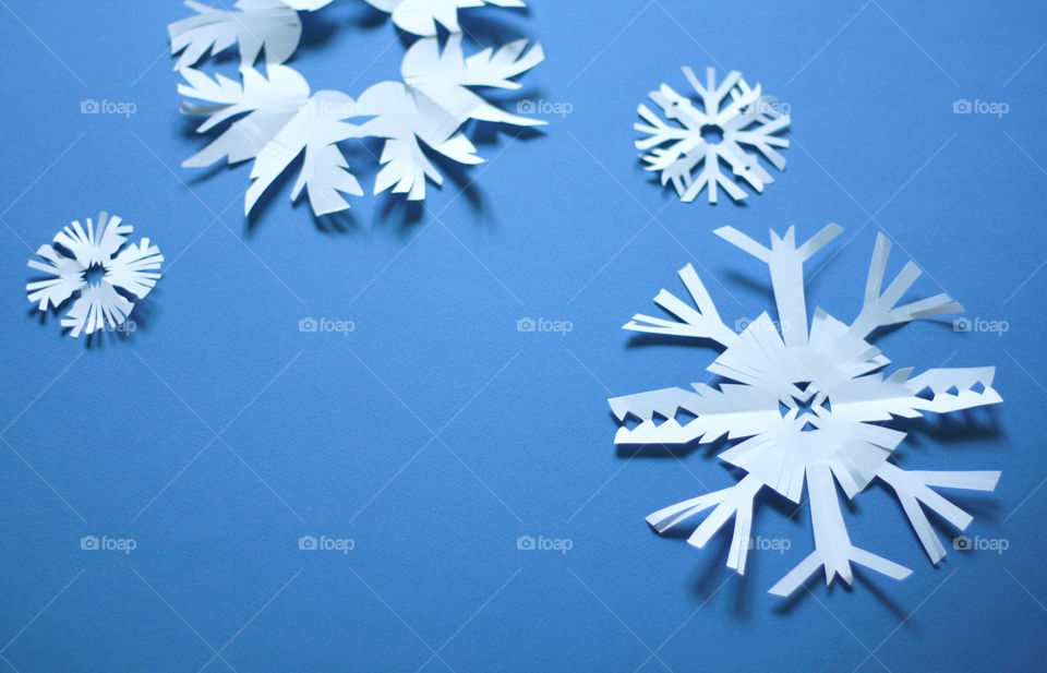Paper snowflakes on blue background