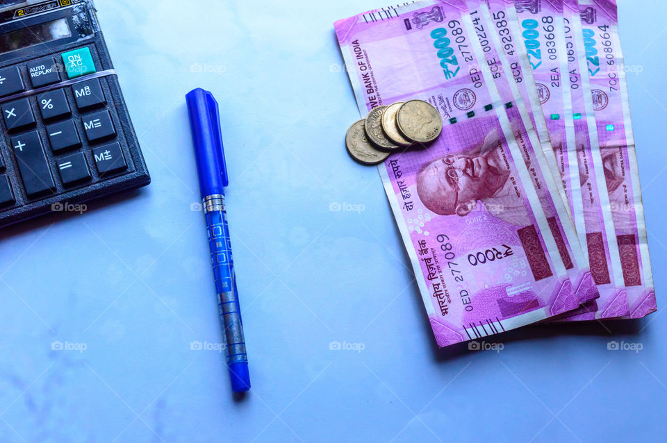 Focus on Gandhi. Indian paper currency rupees and coins stack, calculator and pen business growth symbol. Studio shot Isolated on white background close up. Planning budgeting funding concept, India.