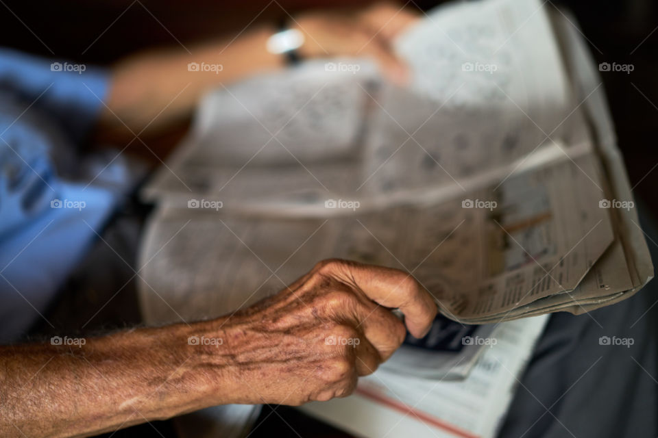 Aging Hands with a Newspaper