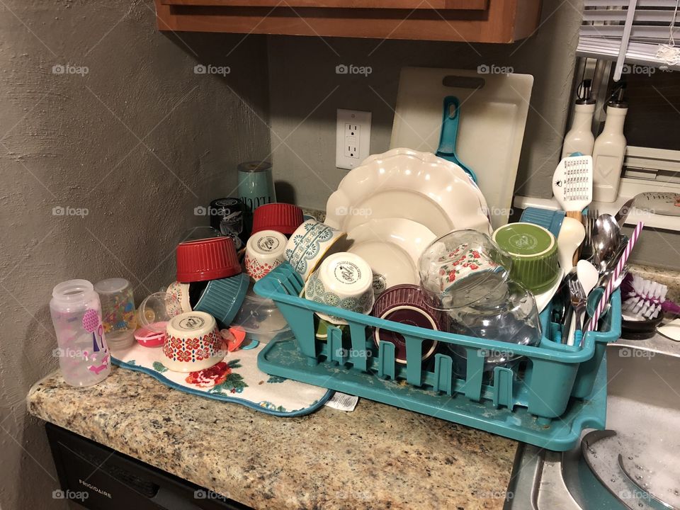 Overloaded dingy dish drainer full of pioneer woman dishes. 