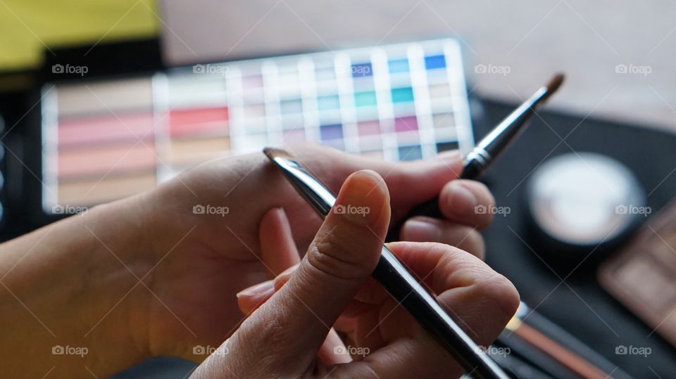 Close-up of hand with make-up brushes