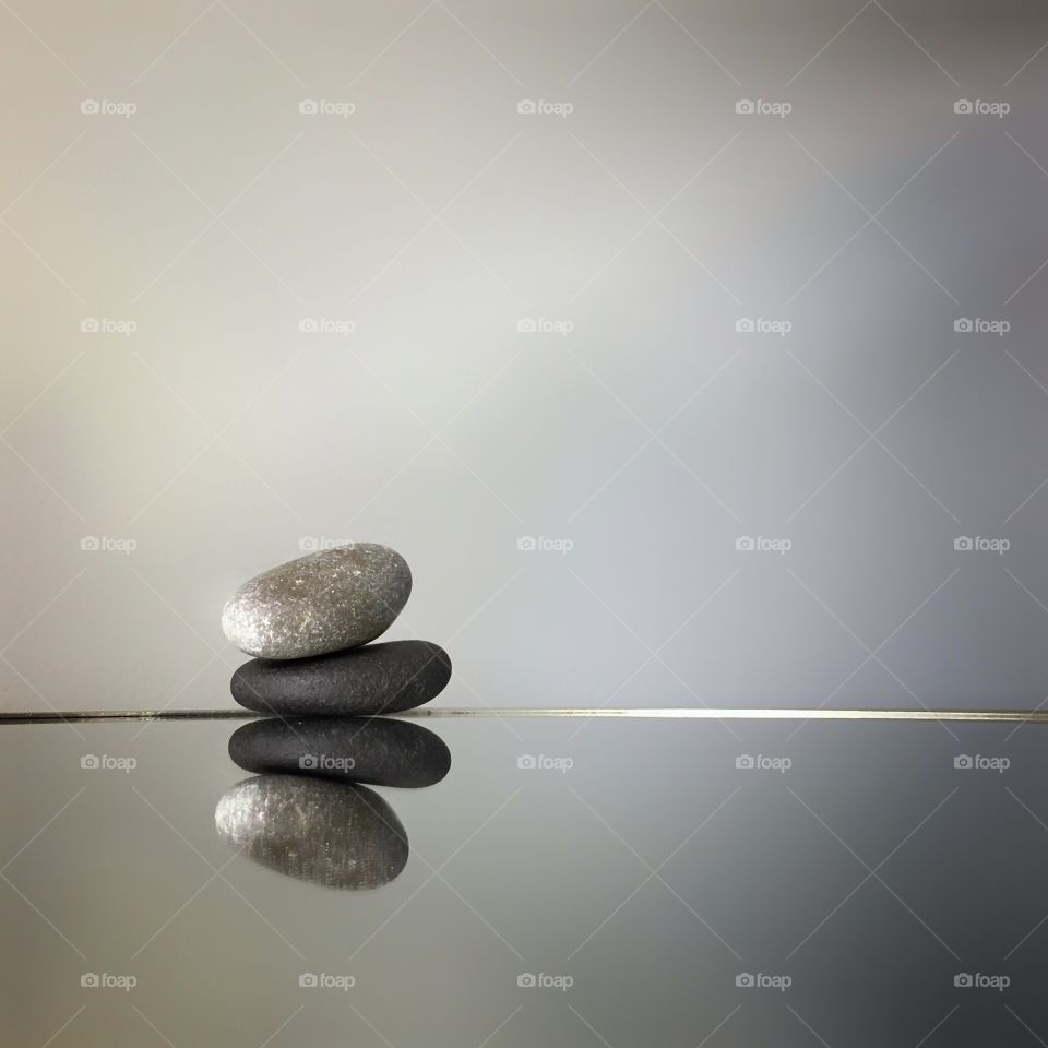 Pebbles balanced on a mirror 