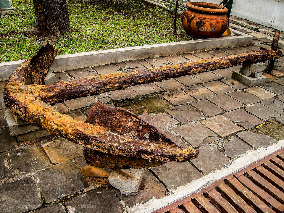Old ship anchor, rusty and fragile. Portuguese heritage in Indonesia