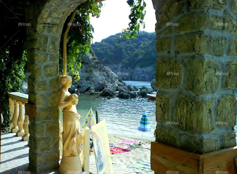 View of a beach at Corfu through an arch